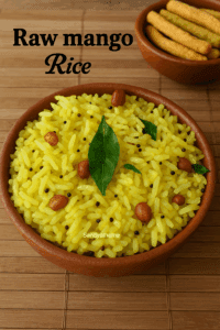 A bowl of vibrant yellow mango rice garnished with curry leaves, mustard seeds, and peanuts, served in a rustic terracotta bowl on a bamboo mat, with a side of murukku snacks.