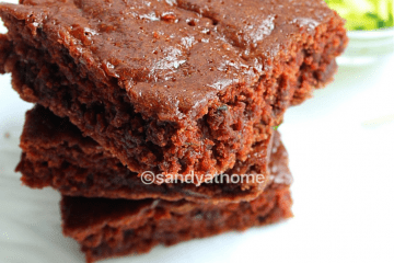 A soft, chocolatey eggless brownie made with zucchini, served on a white plate with crumbs around