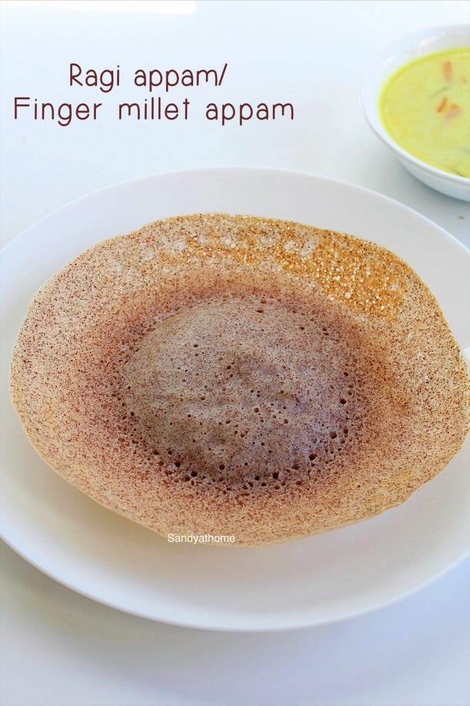 Millet appam served in traditional appam pan with lacy edges and soft center, paired with coconut milk in a brass bowl