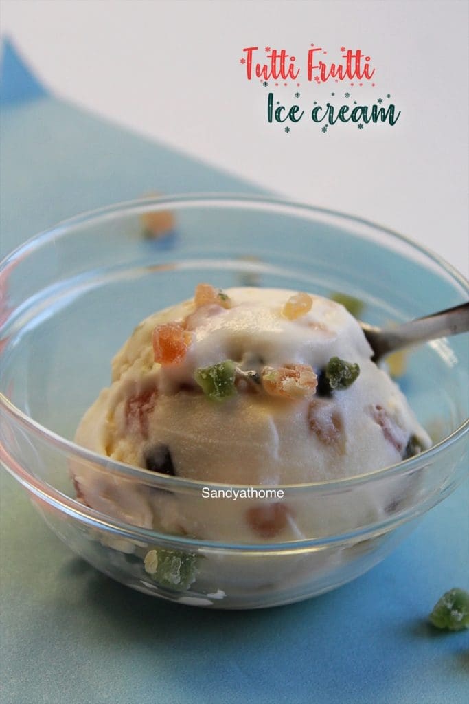 Close-up of homemade tutti frutti ice cream scooped in a bowl, topped with colorful candied fruit