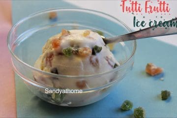 Creamy tutti frutti ice cream scooped using an ice cream spoon, set against a summer backdrop
