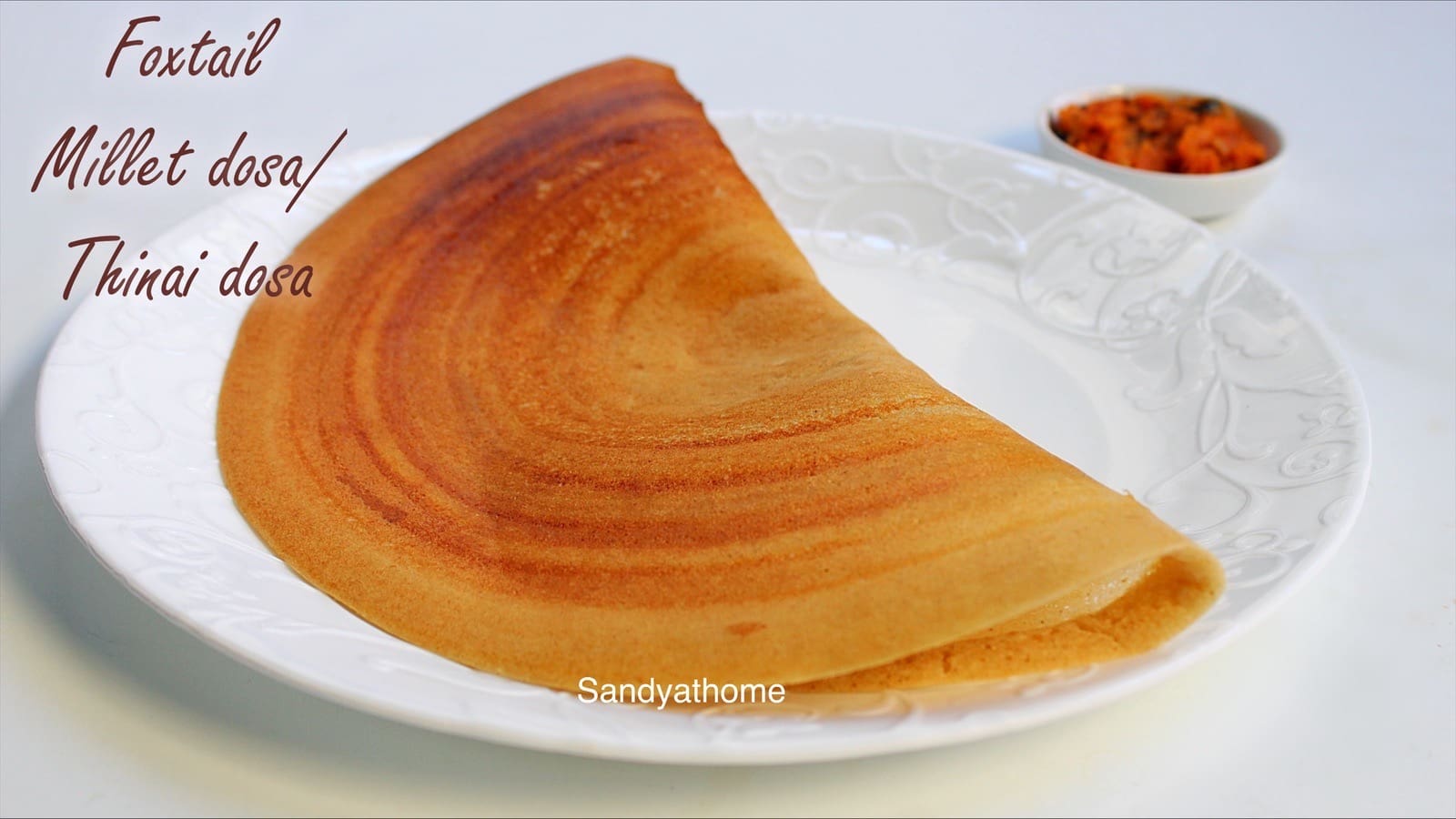 Crispy thinai dosa served on banana leaf with coconut chutney on the side