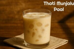 Chilled nungu paal served in a glass with visible ice apple pieces floating in sweet milk
