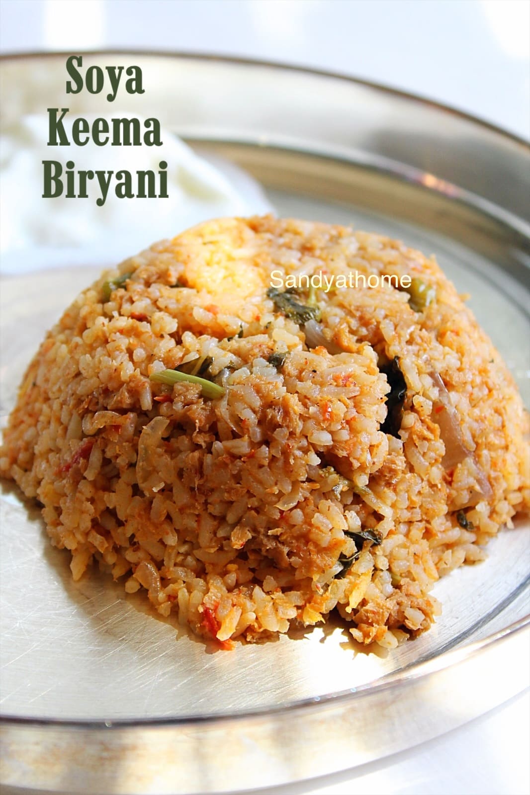 South Indian-style vegetarian keema biryani made using soya granules and aromatic spices, served in a brass pot.
