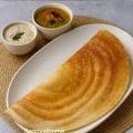 Crispy fermented oats dosa with golden edges served as a gluten-free South Indian meal with chutney and sambar