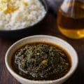 South Indian curry leaves pickle (Karuveppilai Nilavu Pachadi) served in a white bowl with gingelly oil shining on top