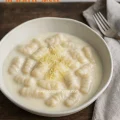 Homemade eggless potato gnocchi topped with a smooth, silky béchamel sauce.